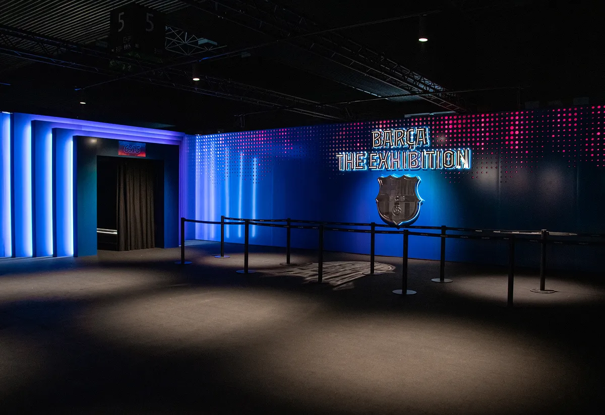 Blue-lit Barça The Exhibition lobby with club imagery and signage
